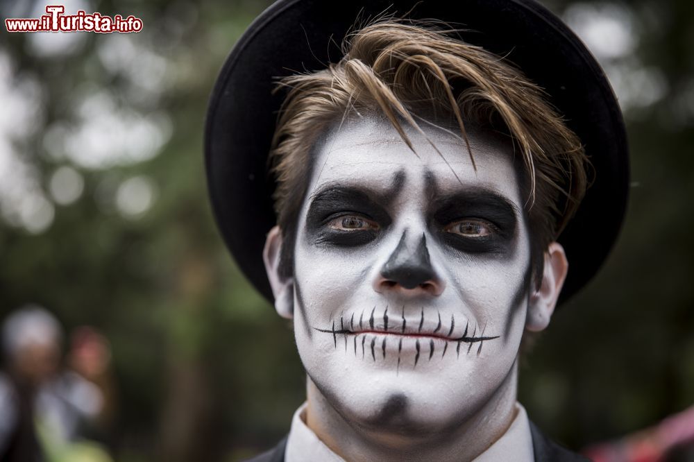 Immagine Un ragazzo con il volto pitturato partecipa al desfile del Día de Muertos a Città del Messico.
