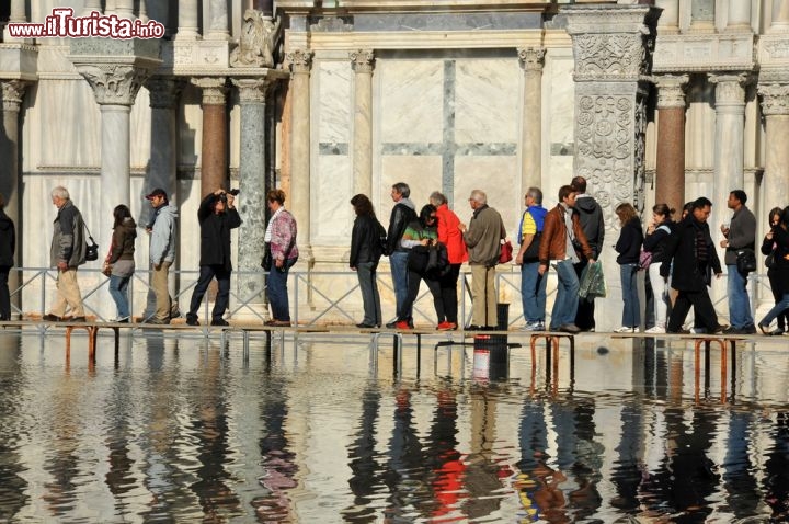 Immagine Acqua alta a Venezia: passerelle pedonali in Piazza San Marco. Il record della marea più alta rimane quello del 4 novembre 1966 quando furono raggiunti i 194 cm di altezza - © mountainpix / Shutterstock.com