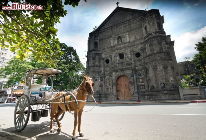 Immagine La scura chiesa di Malate con un tipico carretto turistico a Manila, la capitale delle Filippine - © Krajomfire / Shutterstock.com