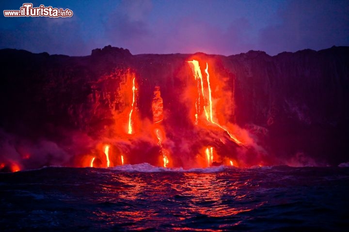Immagine Isola di Hawaii, nell'omonimo arcipelago del Pacifico: colate di lava lungo la costa rocciosa che si tuffano in mare. Di notte il contrasto cromatico tra il fuoco e il buio è uno spettacolo tanto attraente quanto inquietante - © Tor Johnson / www.hvcb.org