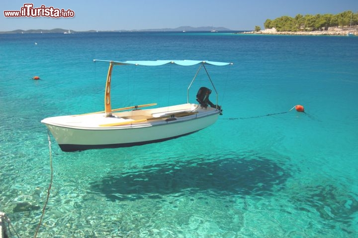 Immagine Il Mare limpido di Brac: una barca in riva ad una spiagga, sembra quasi volare, tanto sono cristalline le acque dell'isola della Croazia, una delle più grandi dell'adriatico oltre che della costa dalmata - © darios/ Shutterstock.com