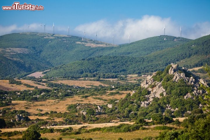 Immagine Panorama della Valle della Luna di Aggius, sullo sfondo alcuni impianti eolici della Sardegna - © CoolR / Shutterstock.com