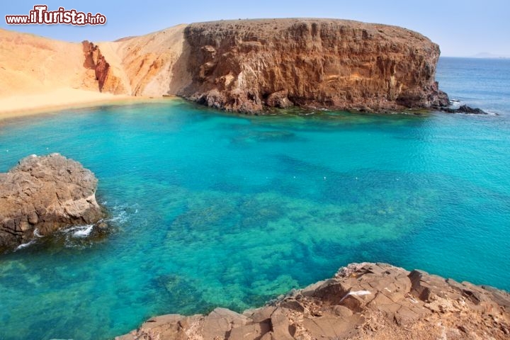 Immagine Playa el Papagayo a Lanzarote, Isole Canarie. Si trova nella porzione più meridionale dell'isola ed è famosa per le sue sabbie dorate e le acque cristalline che invitano a fare snorkeling - © holbox / Shutterstock.com
