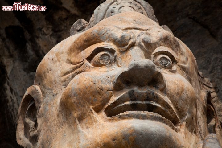 Immagine Primo piano di una statua di Budda nelle grotte di Longmen a Luoyang in Cina. Le grotte hanno subito un grave saccheggio all'inizio del XX secolo e durante la rivoluzione maoista - © Dropu / Shutterstock.com