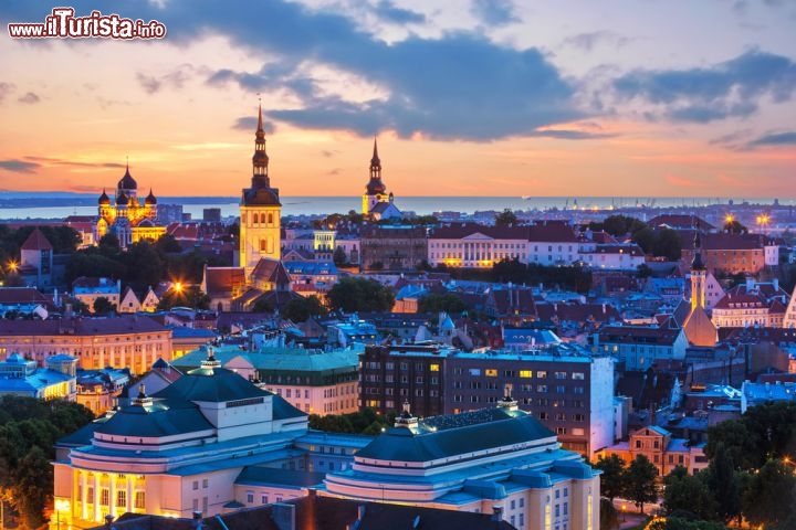 Immagine I tetti di Tallinn, capitale estone, si tingono di rosa e azzurro al tramonto, mentre iniziano ad eccendersi le luci romantiche della sera - © Oleksiy Mark  / Shutterstock.com