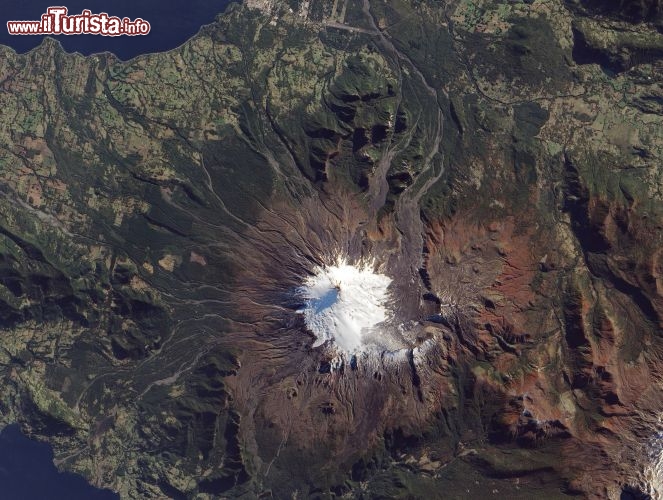 Immagine Il Volcan Villarrica visto da satellite, si notano le nevi che ricoprono la cima del grande stratovulcano, alto quasi 2.850 metri e le rive del Lago Villarica dove si trova Pucon. Ci troviamo nel Cile meridionale, sulle Ande, non distanti dall'inizio della Patagonia.
