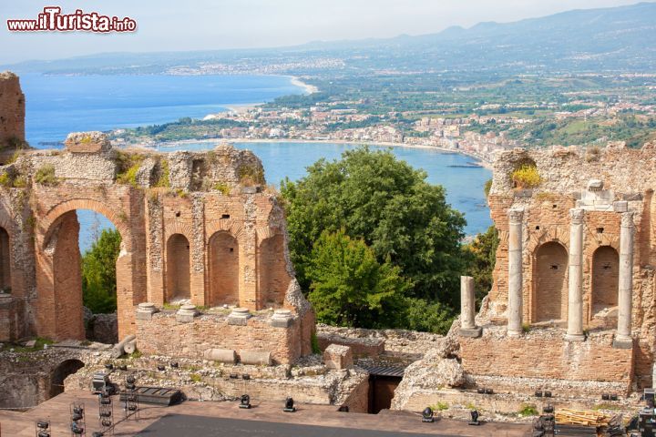 Immagine L'anfiteatro romano-greco di Taormina con  Giardini Naxos sullo sfondo, Sicilia. Nonostante l'origine ellenistica, il teatro della città si presenta oggi con un aspetto totalmente romano.