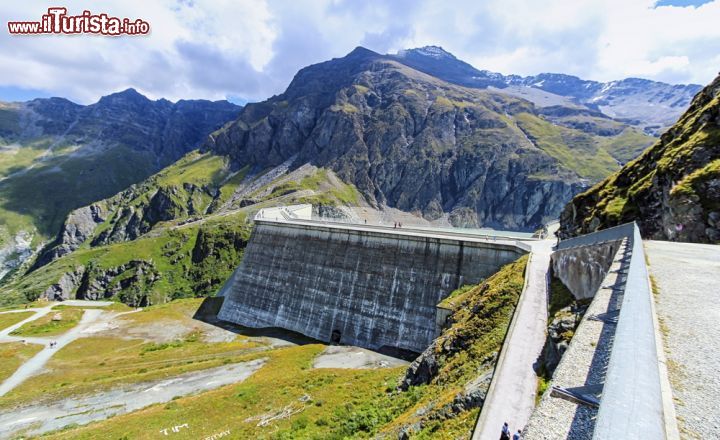 Immagine Uno scorcio panoramico sulla diga Grande Dixence, che con i suoi 285 metri rappresenta la più alta diga di sbarramento al mondo, nella val d'Héreménce. Le acque di fusione di 35 ghiacciai dei dintorni di Zermatt sono raccolte da questa struttura costruita nel 1951-65 con dimensioni decisamente incredibili che oltre all'altezza che sfiora i 300 metri prevede uno spessore di 200 metri alla base e una lunghezza di 695 metri. Questo vasto lago artificiale, per la cui costruzione sono stati necessari 6 milioni di metri cubi di cemento, contiene quasi 400 milioni di metri cubi di acqua convogliati da oltre 100 chilometri di gallerie - © Elenarts / Shutterstock.com