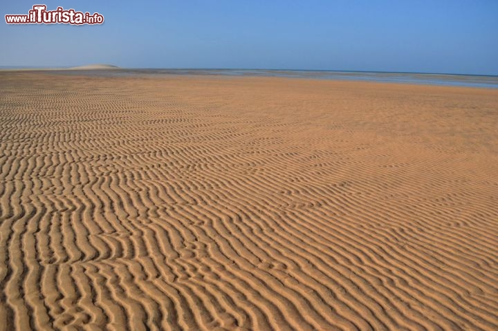Immagine Duna Bianca, Dakhla: sullo sfondo, in lontananza, l'inconfondibile sagoma della Duna Bianca appare in questo tratto di deserto in riva alla laguna.