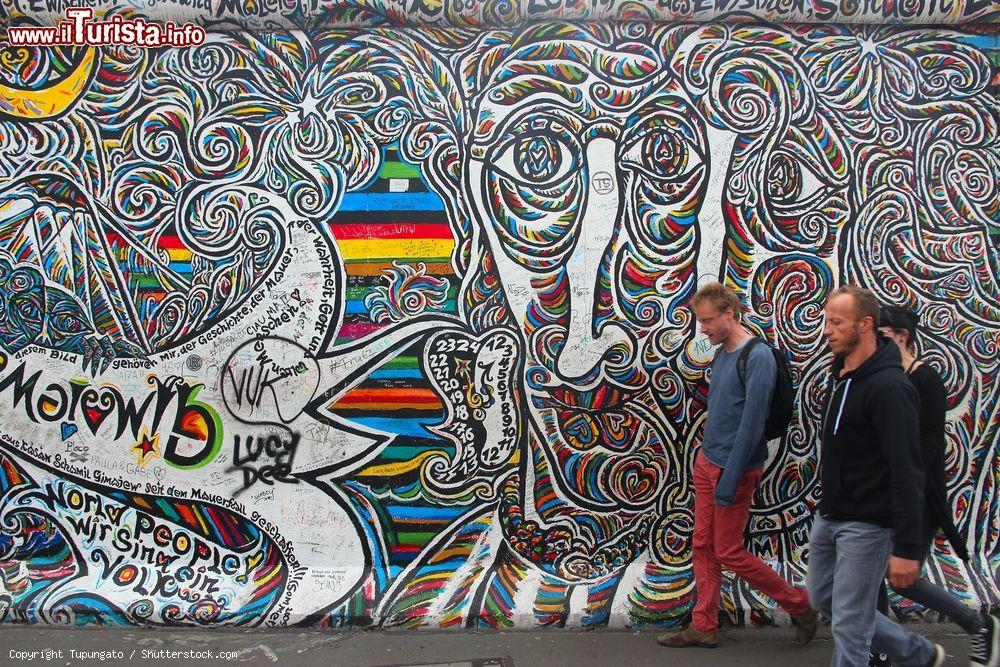 Immagine Turisti visitano la East Side Gallery: una parte del muro di Berlino ricoperta da apere di più di 100 artisti dal 1990. - © Tupungato / Shutterstock.com