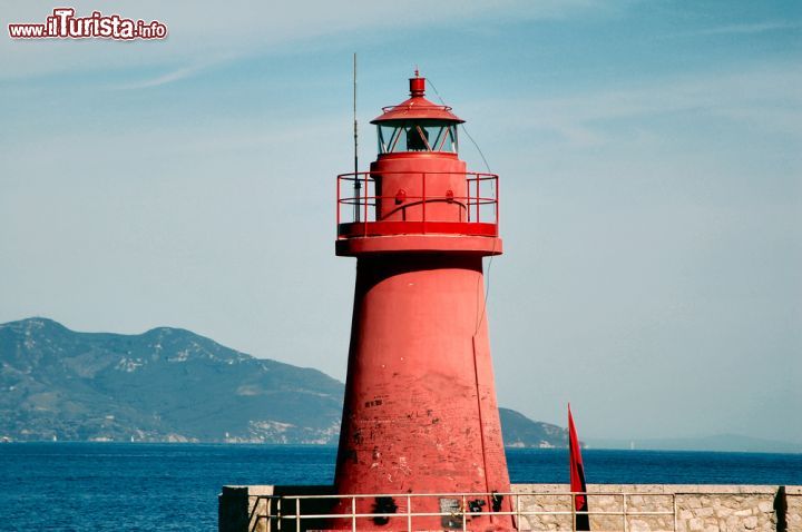 Immagine Il faro rosso del porto dell'isola del GIglio, il punto di arrivo dei traghetti dall'Argentario - © maurizio / Shutterstock.com