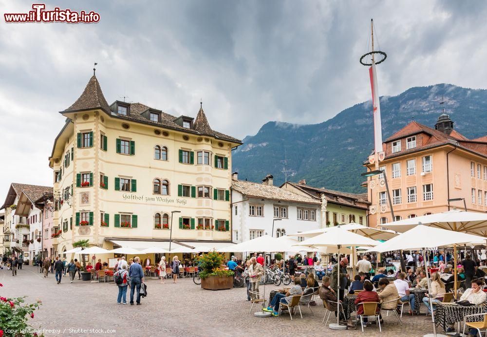 Immagine La piazza principale nel centro di Caldaro, Trentino Alto Adige. Il grande piazzale del mercato ospita tavoli e sedie di ristoranti e locali - © manfredxy / Shutterstock.com