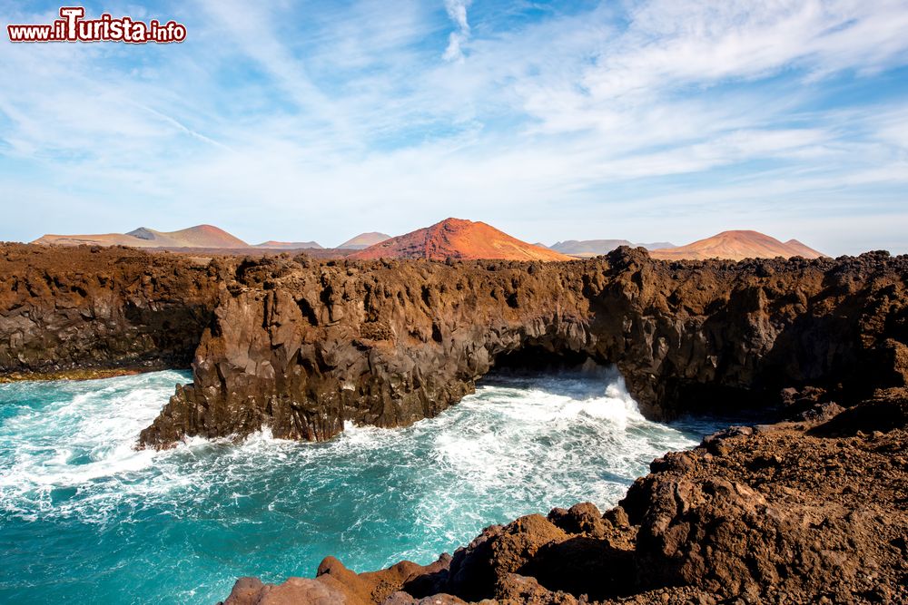 Immagine Los Hervideros: la costa battuta dalle onde dell'Oceano Atlantico. Sullo sfondo i vulcani, immancabili nel panorama di Lanzarote (Canarie).