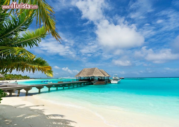 Immagine La passerella che conduce alle capanne costruite sull'acqua in un resort su un atollo delle Maldive - foto © sf2301420max / Shutterstock.com