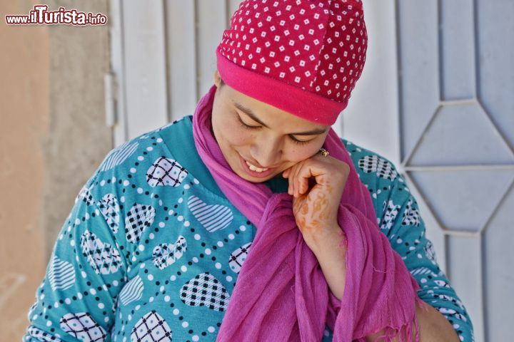 Immagine Donna nel centro di Marrakech, Marocco - Abbigliamento dai colori sgargianti, sorriso e tatuaggio all'henné per questa giovane donna fotografata nella città imperiale