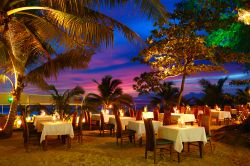 Lungo la costa di Phuket ci sono ristoranti e alberghi esclusivi che servono romantiche cene sulla spiaggia: le foglie delle palme sulla testa e la sabbia sotto i piedi, insieme ai colori del ...