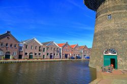 Dettaglio di un mulino a vento nei pressi di un canale a Schiedam, Olanda. Di fronte alle ordinate e graziose casette in tipico stile olandese si innalza uno dei mulini a vento che si affacciano ...