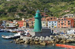Il faro della marina di GIglio Porto, sullo sfondo le case del borgo marinaro - © trotalo / Shutterstock.com