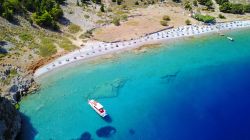 Foto dal drone della spiaggia rocciosa di Nannou sull'isola di Symi, Grecia. Con i suoi ciottoli è una delle più selvagge e famose dell'isola greca.

