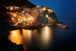 Fotografia notturna del borgo di Manarola illuminato, Cinque Terre, Liguria. Provenendo da La Spezia è il secondo villaggio delle Cinque Terre.
