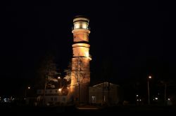 Il faro illuminato di notte nel distretto di Travemuende a Lubecca, Germania.
