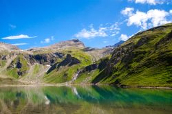 Il lago alpino Nassfeld Speicher nell'Hohe Tauern National Park, Austria. Il verde delle montagne si riflette nell'acqua del bacino creando un suggestivo gioco di colori.
