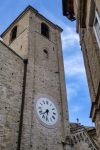 La torre dell'orologio nel centro storico di Fermo, Marche, affaciata su una tipica stradina.
