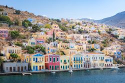Le case variopinte nel porto di Symi, isola di Symi, Grecia. Ottava isola più grande del Dodecaneso, Symi è caratteristica per le sue case costruite sulle pendici: sono in stile ...