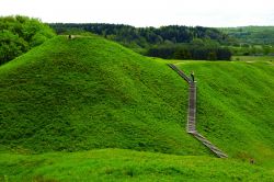 Le verdi colline archoelogiche del villaggio di Kernave, Lituania. Ci si inerpica grazie a delle scale in legno.
