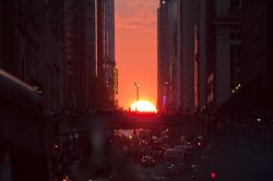 Manhattanhenge a New York, Stati Uniti. Il sole tramonta due volte l'anno tra i grattacieli di New York City. Le strade con la miglior vista sono la 14/ma, 23/ma, 34/ma, 42/ma e 57/ma, indirizzando ...