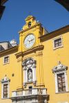 Palazzo storico con orologio, statua e balcone nel centro di Fermo (Marche).
