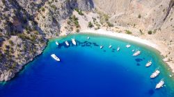 Panorama dall'alto della spiaggia di Agios Georgios con yachts e barche ormeggiate, isola di Symi (Grecia).


