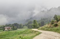 Panorama di un sentiero con una casa sui monti di Montagnole Basse, Alpi italiane, Recoaro Terme, Veneto, in una giornata di foschia - © Isacco / Shutterstock.com