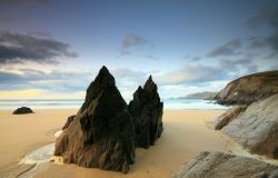 Spiaggia di Coumeenole nella penisola di Dingle, Irlanda. La sabbia dorata di questo angolo di costa irlandese è impreziosita da bizzarre formazioni rocciose che si innalzano creando ...