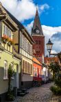 Una strada acciottolata nel centro storico di Aalborg (Danimarca) si insinua tra le case colorate e il campanile della chiesa alle loro spalle - © foto Anders Riishede / Shutterstock.com ...