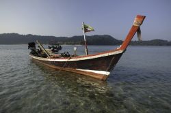 Tipica barca in legno ancorata al largo di una spiaggia nell'arcipelago di Mergui, Myanmar.

