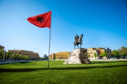 Tirana, piazza Skanderbeg con la bandiera albanese e il monumento equestre all'eroe nazionale.



