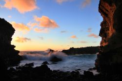 Tramonto dalle grotte di Ana Kai a Rapa Nui, Oceano Pacifico, Cile. E' una delle grotte più visitate dell'isola per la sua spettacolare posizione lungomare e le leggende che la ...