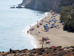 Turisti in spiaggia sul litorale di Anafi, Grecia. Alcune calette sabbiose possono essere raggiunte comodamente dalla strada mentre per ammirare quelle più isolate bisogna avventurarsi ...