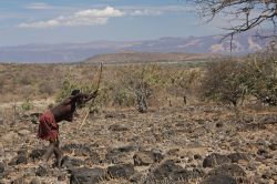Un uomo di una tribù a caccia con arco e frecce sul lago Eyasi, vicino ad Arusha in Tanzania