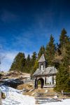 Una chiesetta in legno nella foresta innevata a Nassfeld, Austria.

