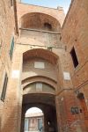 Una porta ad arco nel borgo di Lucignano d'Arbia, Toscana, Italia. Lucignano è un bel villaggio fortificato a pianta circolare; nonostante il trascorrere del tempo ha saputo conservare ...