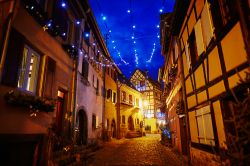 Una stradina del centro storico di Eguisheim by night, Alsazia, decorata per il Natale (Francia).
