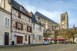Una stradina della città di Bourges con case a graticcio e la cattedrale sullo sfondo, Francia.

