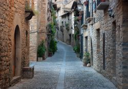 Una vecchia stradina del villaggio medievale di Ainsa, Spagna. Sulle viuzze acciottolate di Ainsa si affacciano antiche dimore trasformate in alloggi dagli arredamenti raffinati.



