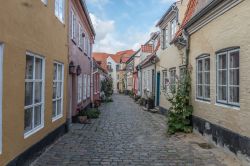 Un'immagine di un vicolo nella città di Aalborg (Danimarca) tra le case sempre ben curate del centro storico - foto © Arth63 / Shutterstock.com