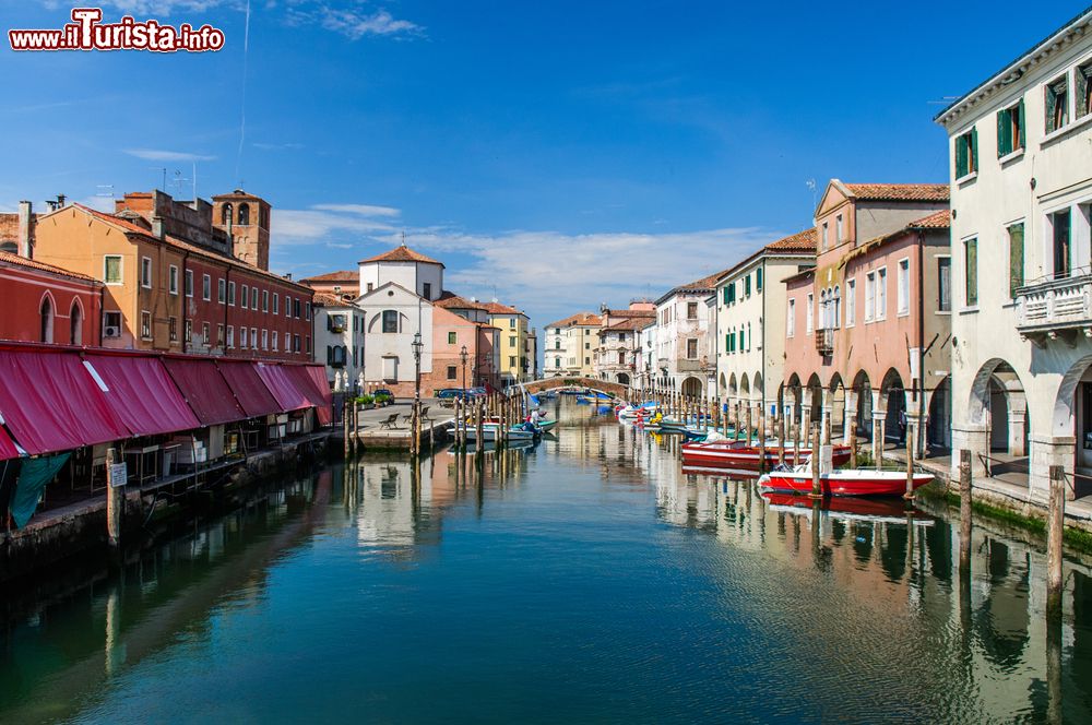 Immagine Un bel panorama del canale con barche, case e riflessi a Chioggia, Veneto, Italia. Il suo territorio si trova nella parte più a sud della provincia di Venezia e si spinge sino alle foci dell'Adige.