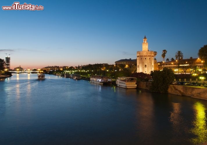 Immagine Siviglia al tramonto sul fiume Guadalquivir, sullo sfondo il Ponte Triana e sulla destra la Torre dell'Oro - © eska2005 / Shutterstock.com