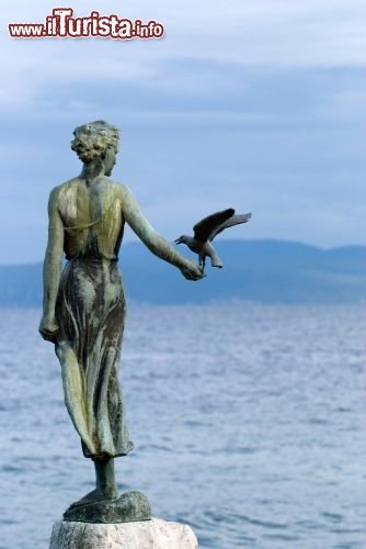 Immagine La statua della ragazza col gabbiano, simbolo della città croata di Opatija (Abbazia), se ne sta aggraziata e elegante vicino al lungomare - © tahi / Shutterstock.com