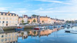 Case affacciate sul porto della città medievale di Vannes, Francia. In primo piano, le barche ormeggiate lungo la banchina.

